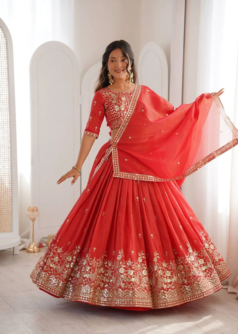 Woman in a red traditional outfit with gold embroidery in a bright room.